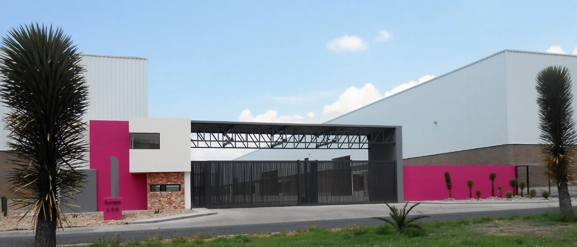 Acceso principal del conjunto Europa 100 con portón corredizo para transporte y caseta de vigilancia, Logistik II